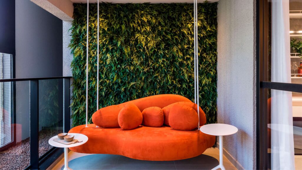 Sofá laranja em ambiente moderno com parede verde