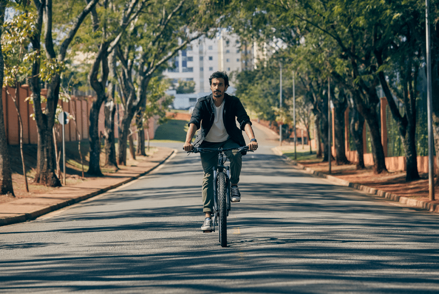 Homem andando de bicicleta no meio da rua