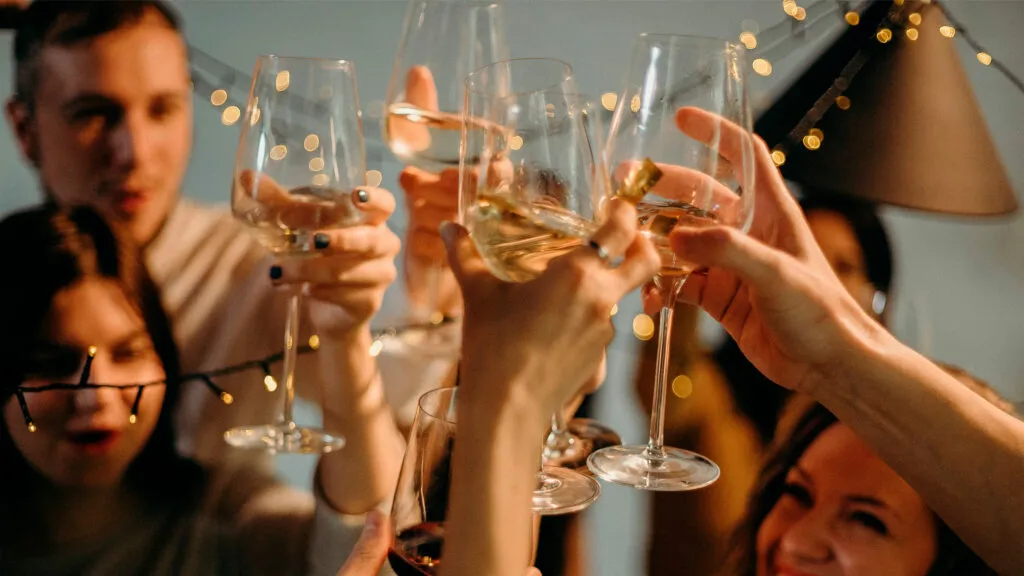 pessoas em festa brindando com taças de champagne