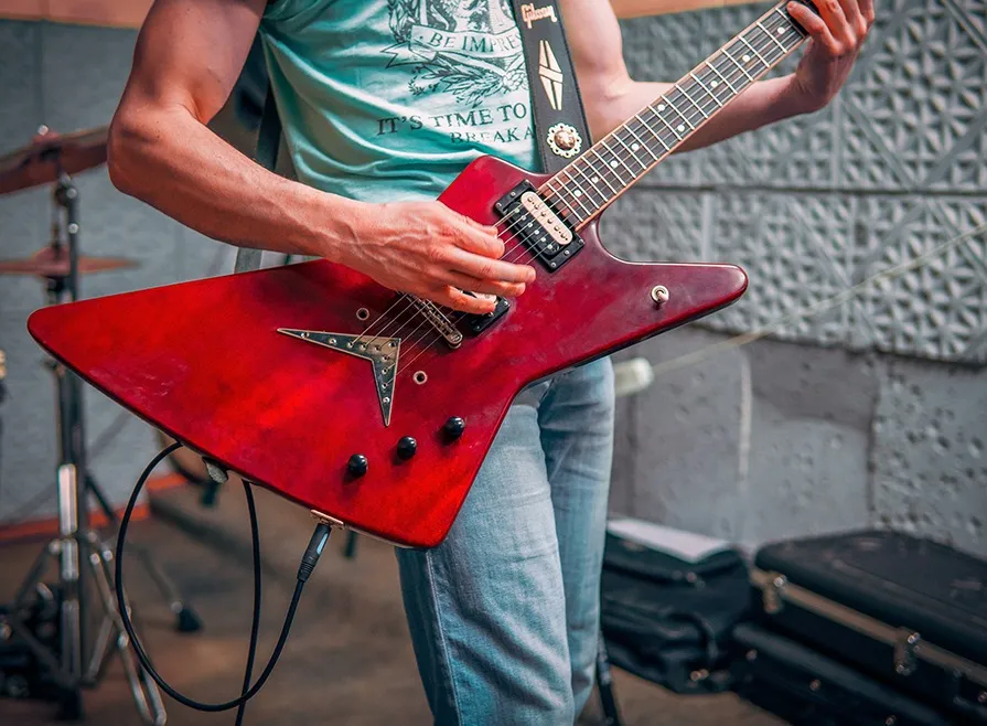 Homem tocando guitarra em um estúdio