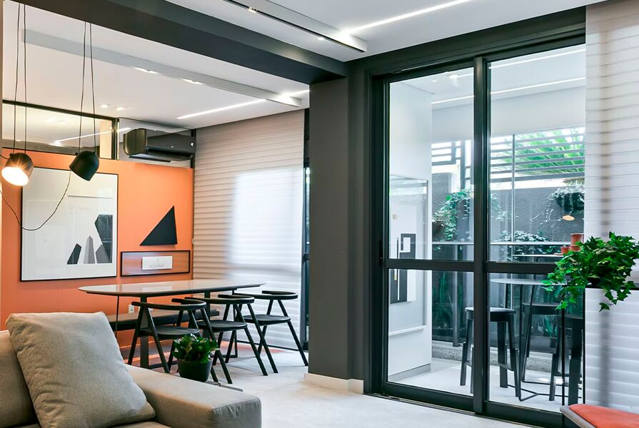 Sala moderna com mesa, sofá e janela iluminada