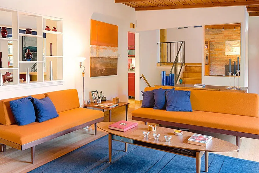 sala com cores na decoração, sofá laranja e almofada azul