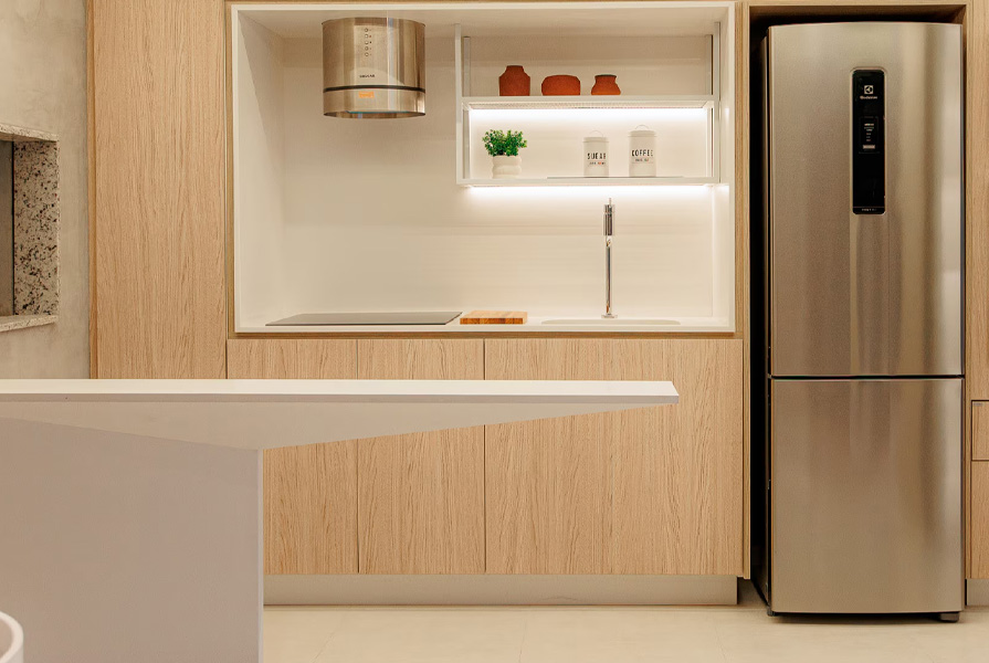Cozinha moderna com armários em madeira e refrigerador inox