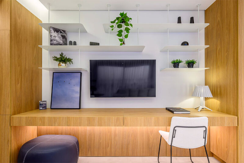 Ambiente moderno com mesa, TV e prateleiras decorativas