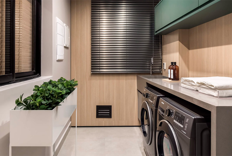Área de lavanderia moderna com máquinas e decoração minimalista.