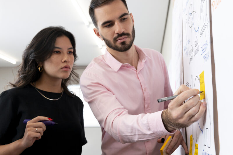 Dupla de profissionais colaborando em brainstorming.