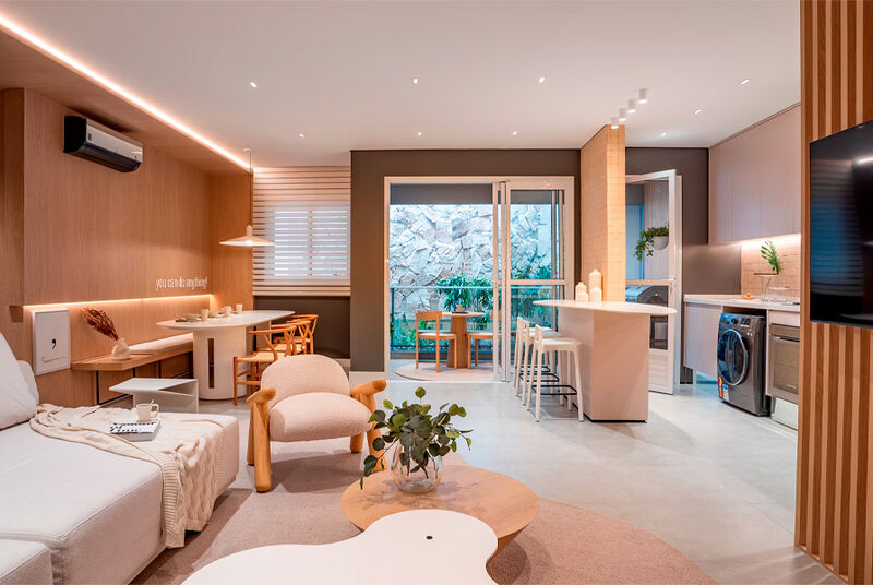 Sala de estar moderna com cozinha integrada e plantas.