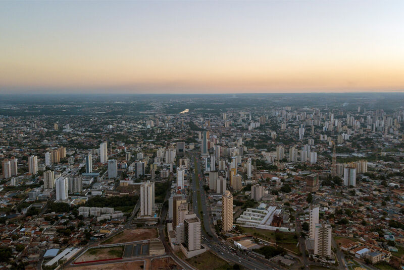 Vista aérea da cidade com prédios e natureza ao fundo
