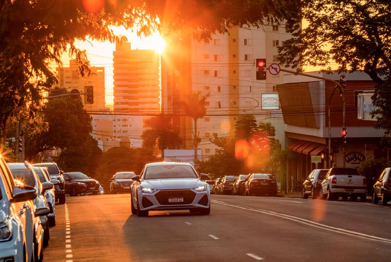 Carro em uma rua iluminada pelo pôr do sol
