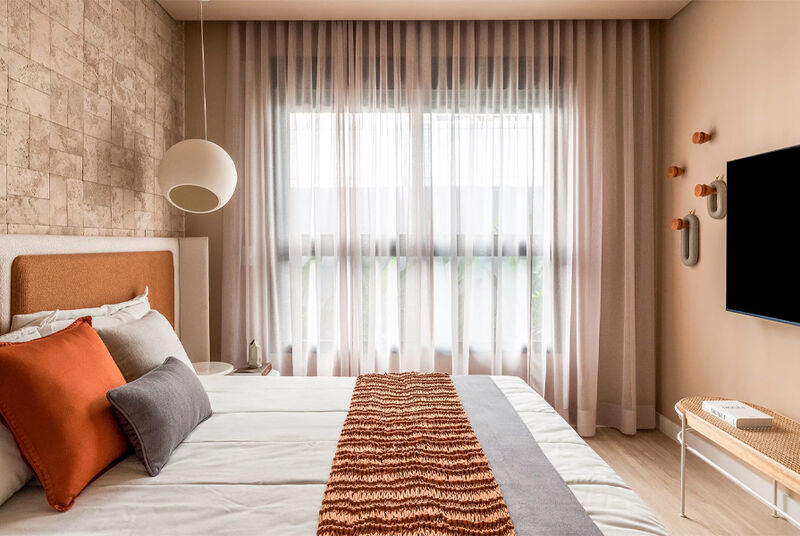 Quarto moderno com cama e cortinas claras