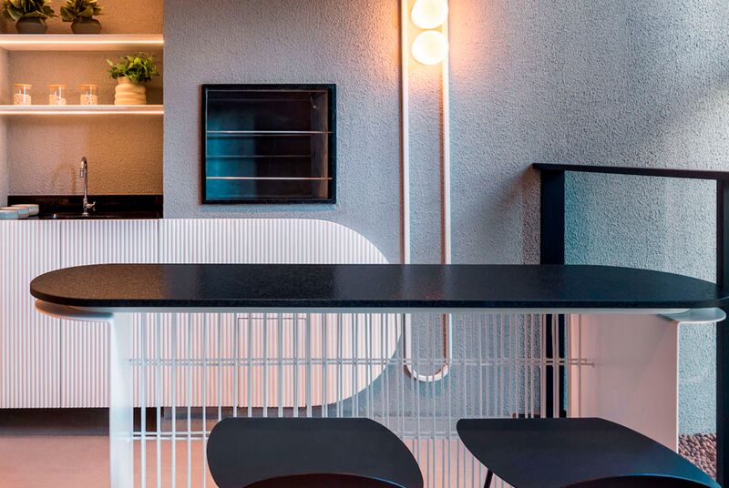 Cozinha moderna com bancada preta e iluminação suave