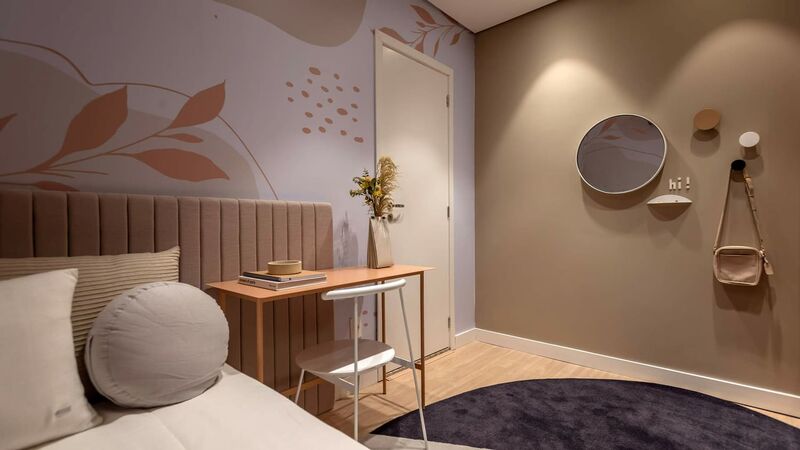 Quarto moderno com parede decorada e mesa de trabalho.
