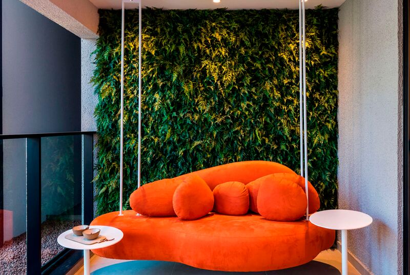 Sofá laranja em ambiente com parede verde