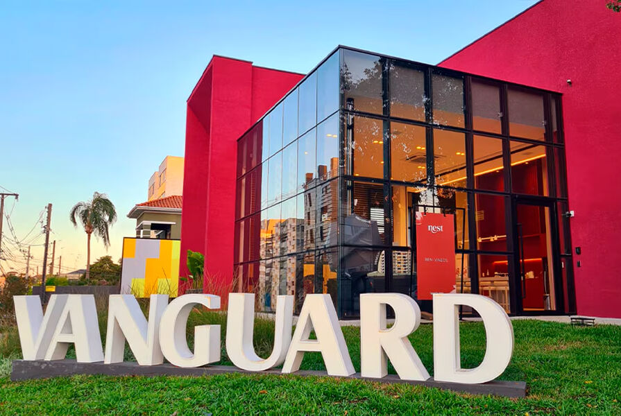 Fachada da loja Vanguard com vidro e parede vermelha